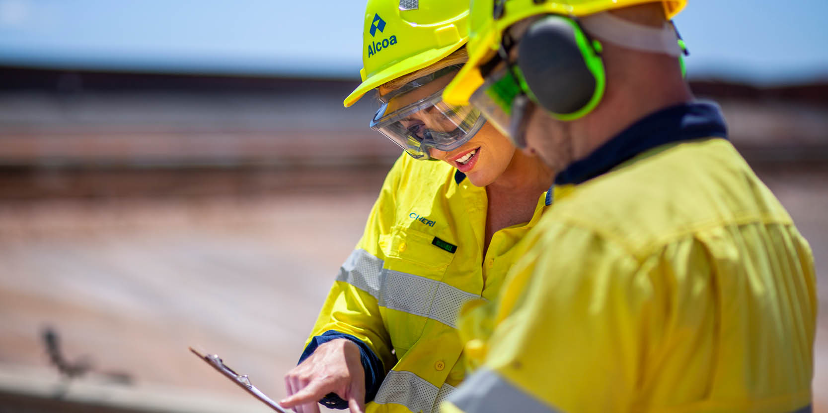 Two people in high vis uniforms looking at a clipboard